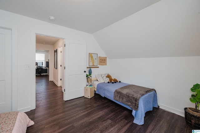 bedroom featuring lofted ceiling, wood finished floors, and baseboards