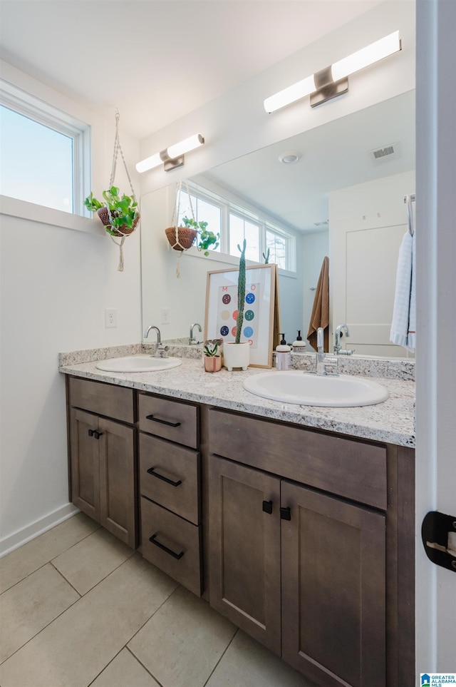 full bathroom featuring tile patterned flooring, double vanity, visible vents, and a sink