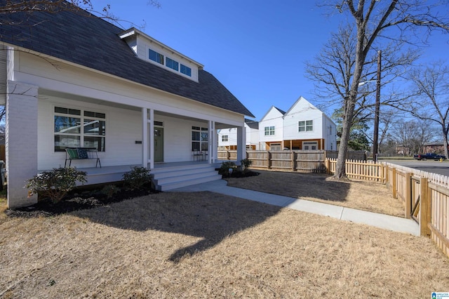 exterior space featuring roof with shingles, covered porch, and a fenced backyard