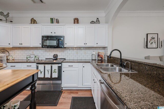 kitchen featuring a sink, stainless steel appliances, crown molding, and light wood finished floors