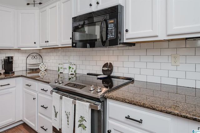 kitchen with electric range, tasteful backsplash, white cabinetry, dark stone counters, and black microwave