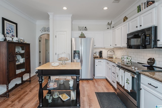 kitchen featuring white cabinets, appliances with stainless steel finishes, light wood-type flooring, and crown molding