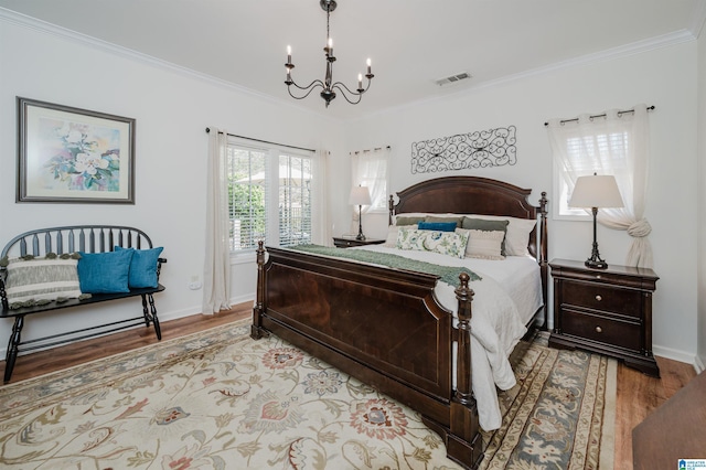 bedroom with visible vents, a notable chandelier, ornamental molding, light wood finished floors, and baseboards