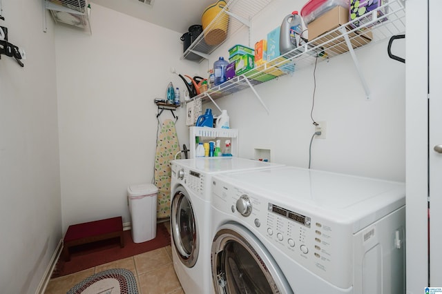 clothes washing area featuring laundry area, light tile patterned floors, and washing machine and clothes dryer