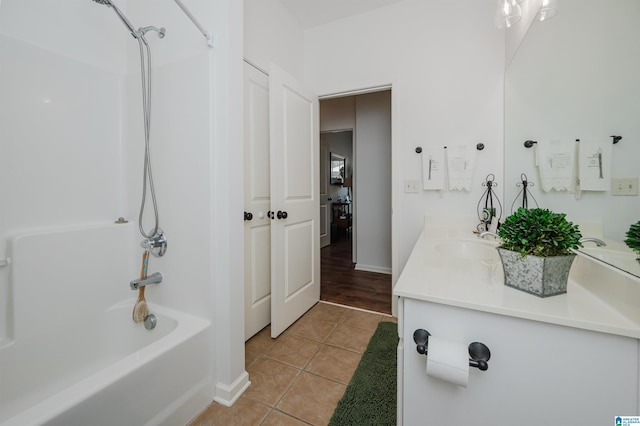 bathroom featuring tile patterned floors, a sink, double vanity, baseboards, and shower / bathtub combination