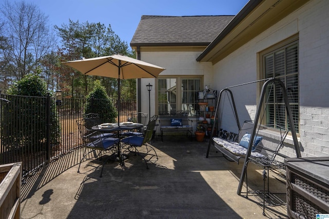 view of patio featuring outdoor dining area and fence