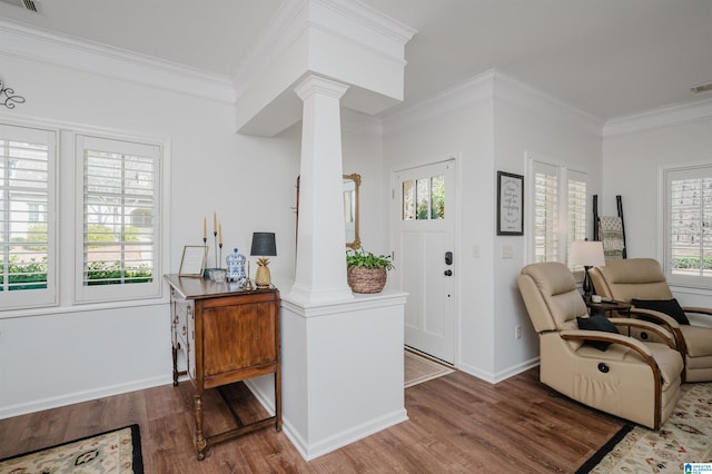 foyer entrance featuring ornamental molding, baseboards, ornate columns, and wood finished floors