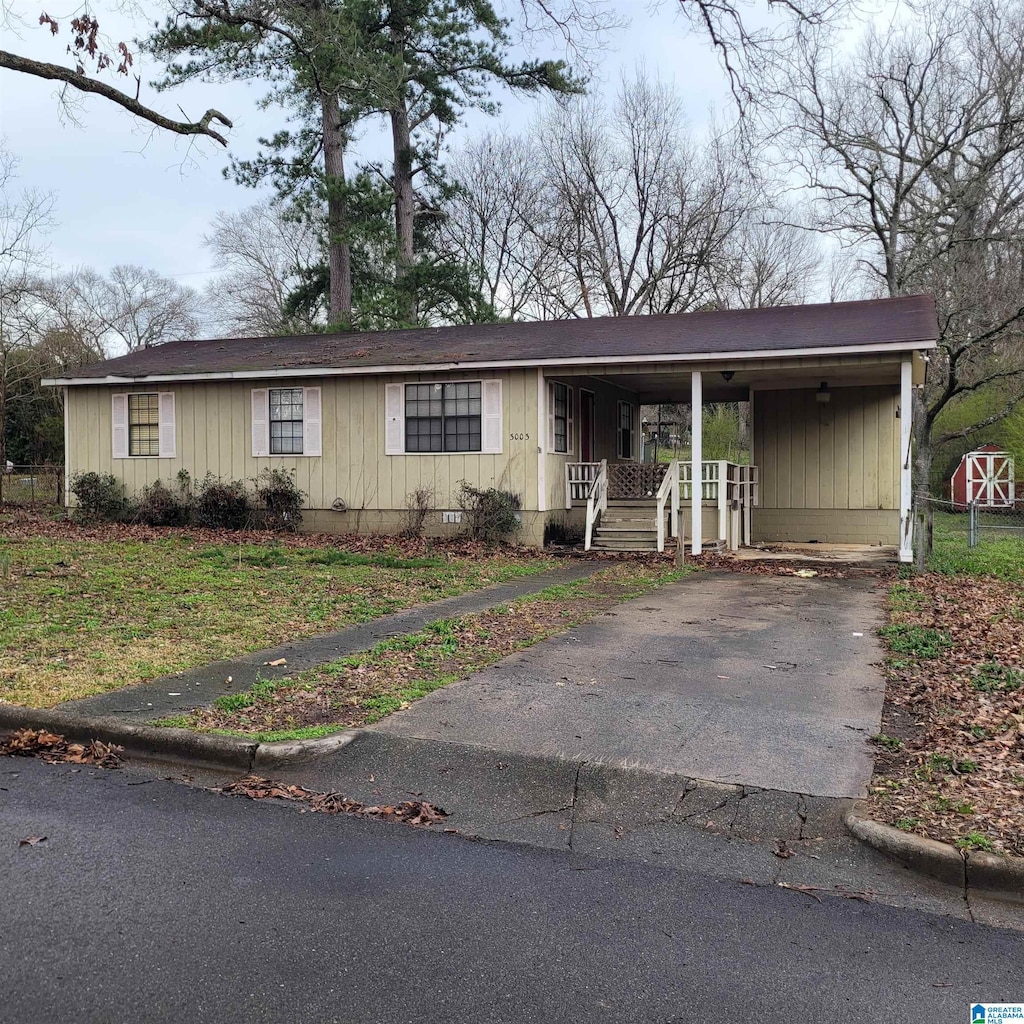 view of front of home with an attached carport, a porch, and driveway