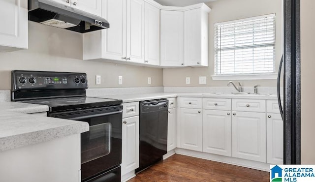 kitchen featuring dark wood-style floors, a sink, black appliances, under cabinet range hood, and white cabinetry