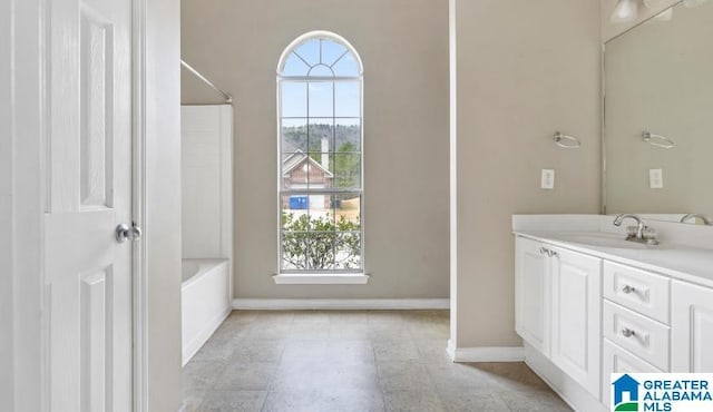 full bathroom featuring vanity, plenty of natural light, bathtub / shower combination, and baseboards