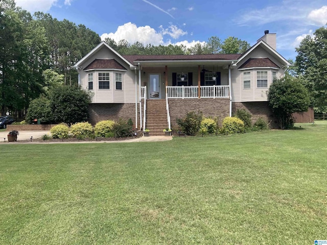 ranch-style home with brick siding, covered porch, a chimney, and a front lawn