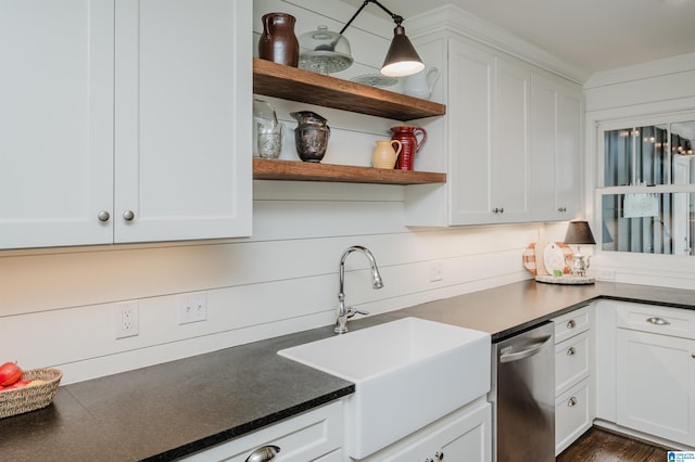 kitchen featuring dark countertops, a sink, white cabinets, and stainless steel dishwasher