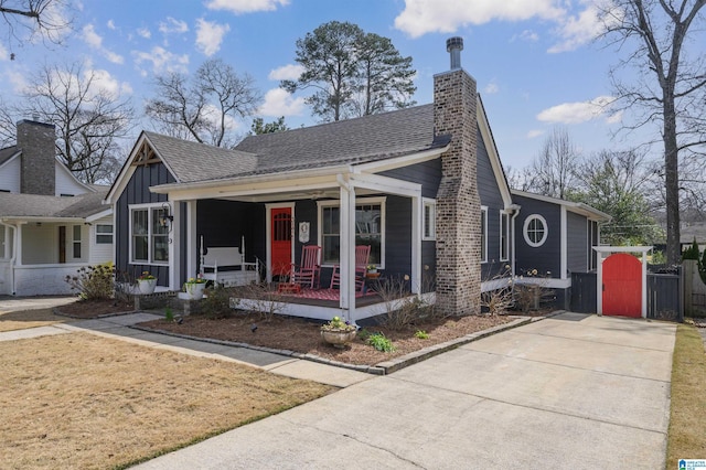 view of front of property with covered porch, board and batten siding, a chimney, and a shingled roof