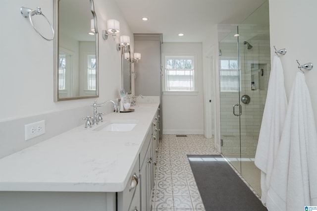 full bath featuring a stall shower, a sink, recessed lighting, double vanity, and baseboards