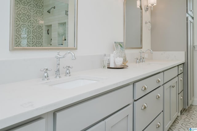 bathroom with a sink, a stall shower, and double vanity