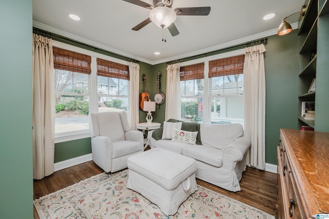 living room featuring dark wood finished floors, crown molding, and ceiling fan