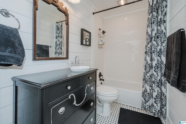 bathroom with wooden walls, toilet, vanity, and shower / bath combo