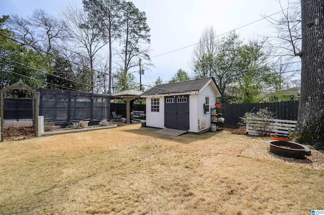 view of yard with a garden, a storage unit, an outdoor structure, and fence