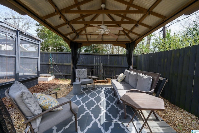 view of patio with a gazebo, an outdoor hangout area, a fenced backyard, and ceiling fan