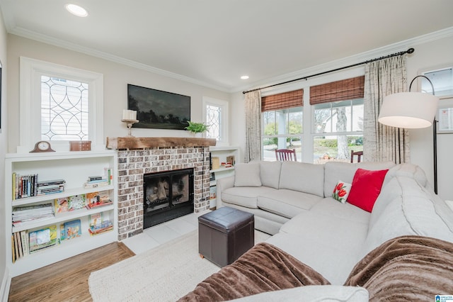 living room featuring crown molding, a brick fireplace, recessed lighting, and wood finished floors