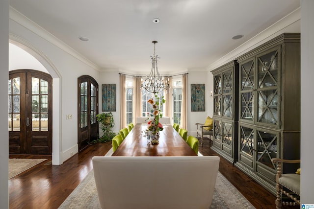 dining space featuring a chandelier, ornamental molding, french doors, and dark wood-style flooring