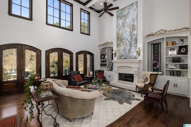 living area with french doors, coffered ceiling, ceiling fan, and wood finished floors