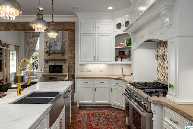 kitchen with a sink, backsplash, a notable chandelier, and appliances with stainless steel finishes