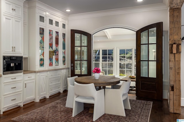 dining area with recessed lighting, arched walkways, dark wood finished floors, and crown molding