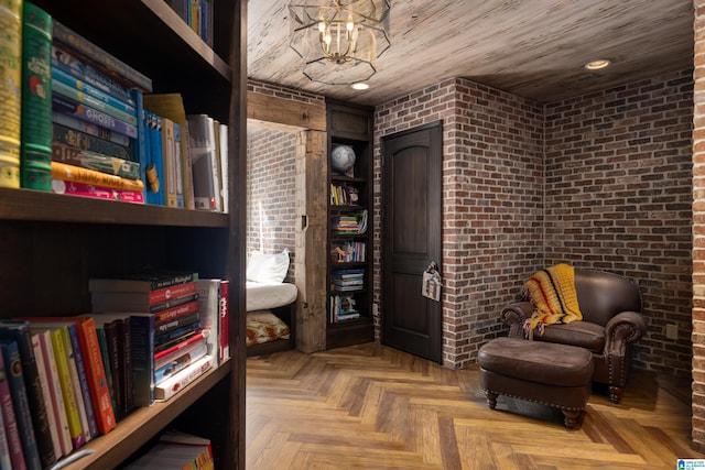 living area featuring recessed lighting, an inviting chandelier, and brick wall