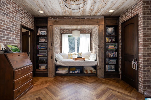 sitting room featuring wooden ceiling, recessed lighting, and brick wall