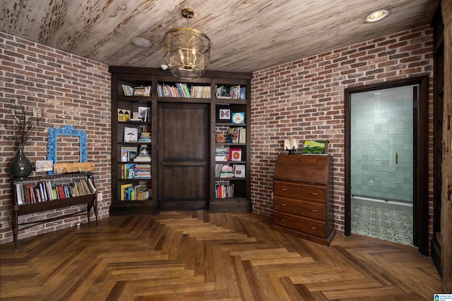 interior space featuring a notable chandelier, brick wall, and wooden ceiling