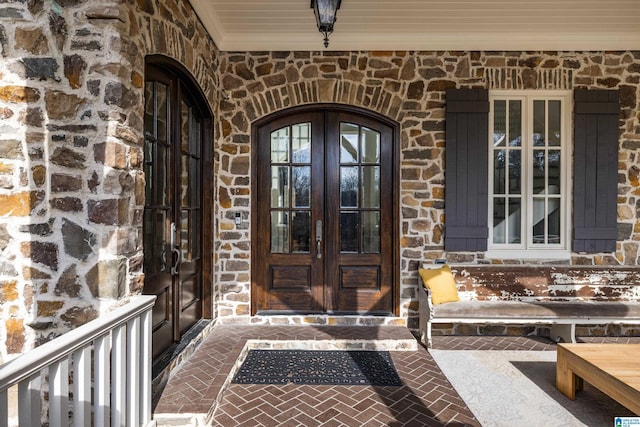 entrance to property featuring french doors and stone siding