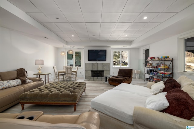 living room with a tray ceiling, recessed lighting, wood finished floors, and baseboards