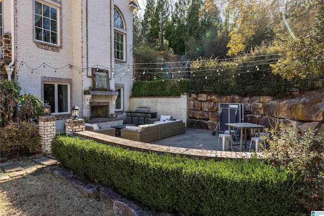 view of patio featuring area for grilling and an outdoor living space with a fireplace