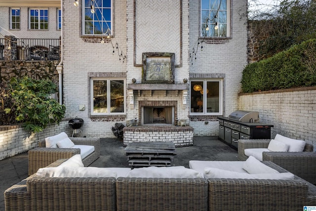 view of patio featuring an outdoor kitchen, an outdoor living space with a fireplace, and a grill