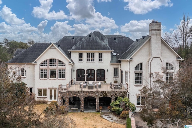 back of property featuring french doors, a patio, and a chimney