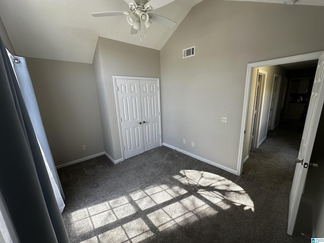 unfurnished bedroom featuring visible vents, baseboards, a closet, high vaulted ceiling, and dark colored carpet