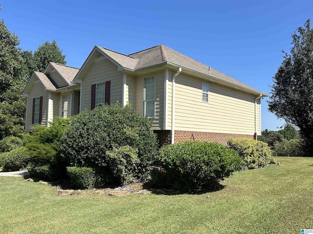 view of side of home featuring a yard and brick siding