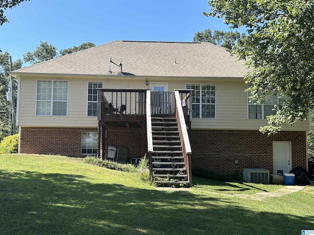 rear view of property featuring brick siding, stairs, a lawn, cooling unit, and a deck