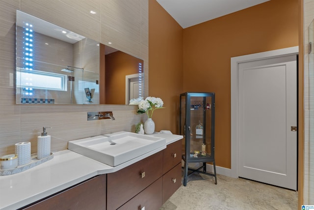 bathroom featuring a tile shower, decorative backsplash, and vanity