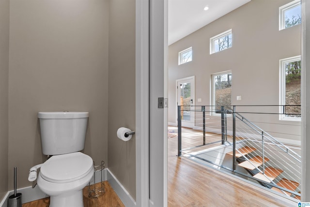 bathroom featuring toilet, wood finished floors, and baseboards