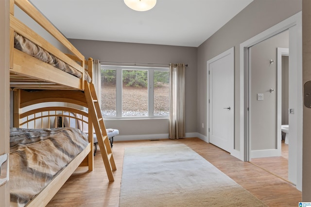 bedroom featuring light wood-style floors and baseboards