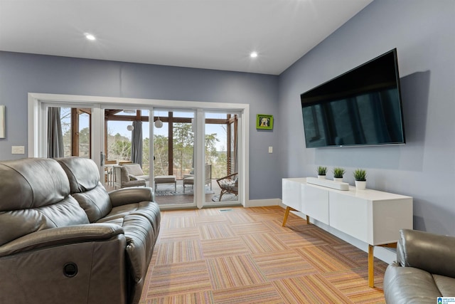 living room featuring recessed lighting, baseboards, and light carpet