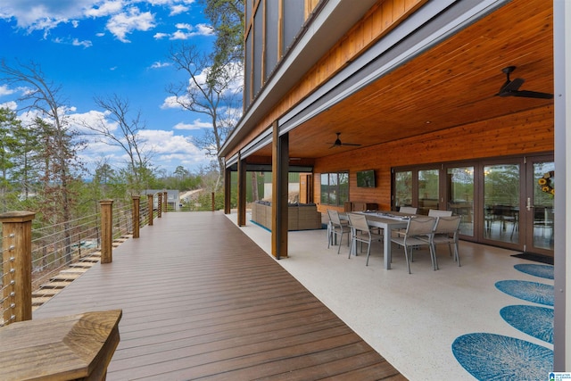 wooden deck with a ceiling fan, an outdoor living space, outdoor dining space, and french doors