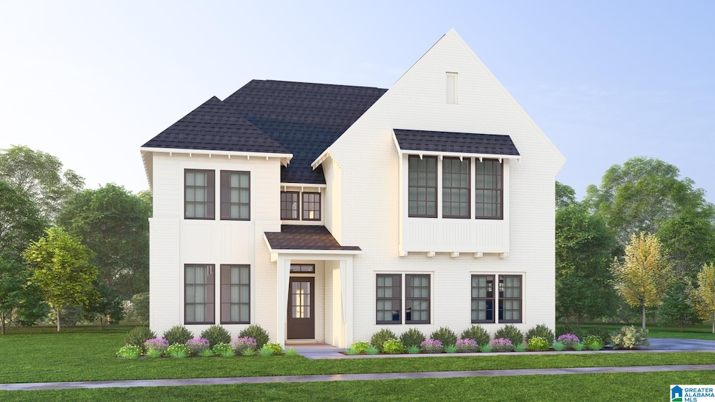 view of front facade with a shingled roof and a front lawn