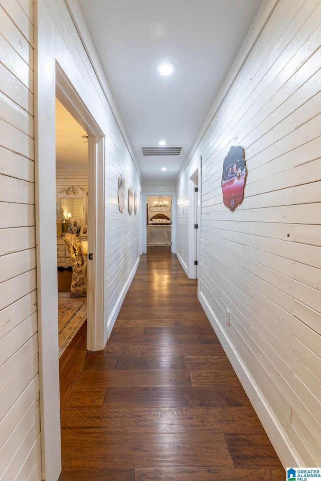 hallway with dark wood finished floors, visible vents, recessed lighting, and baseboards