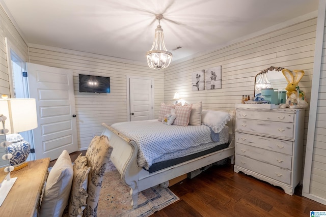 bedroom featuring dark wood finished floors, visible vents, and an inviting chandelier