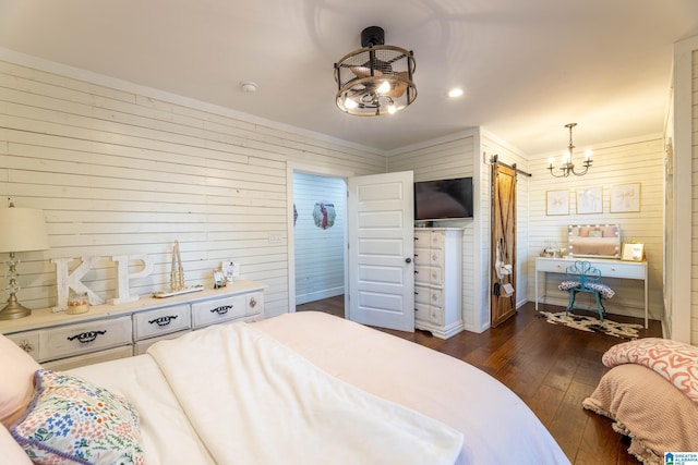 bedroom with an inviting chandelier, crown molding, dark wood-type flooring, and a barn door