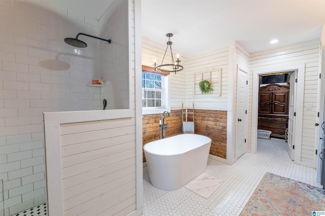 full bathroom with a freestanding tub, walk in shower, wood walls, and a chandelier