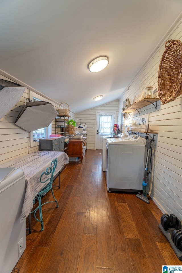 laundry area featuring dark wood finished floors, laundry area, and washer and clothes dryer